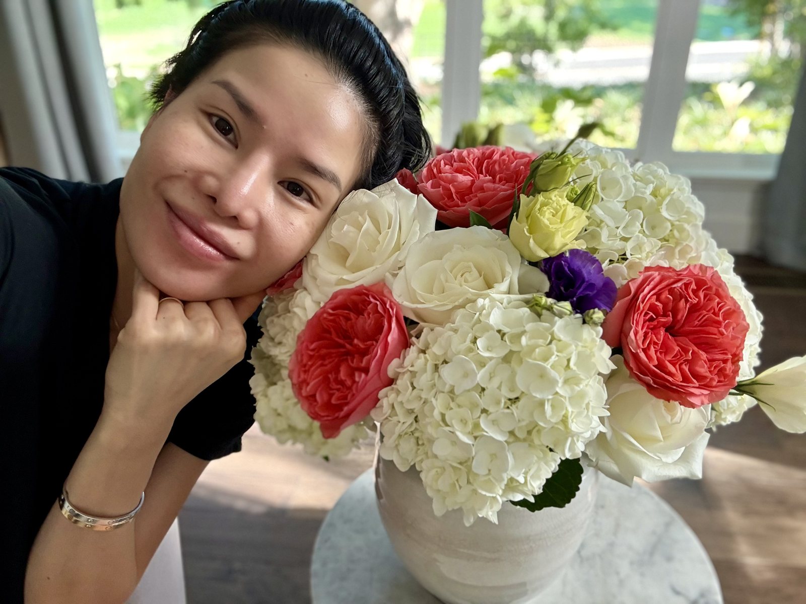 Tina Hillier with a coral rose and hydrangea arrangement